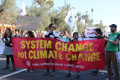 <p>“System change, no  climate change” (İklim değişikliği değil, sistem değişikliği) yazılı pankart<br />Fotoğraf:  John Englart (CC)</p>