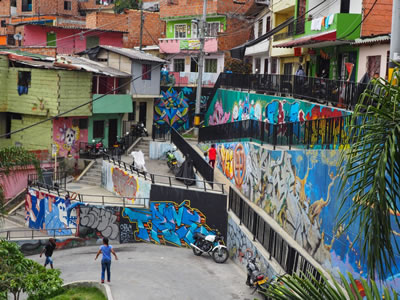 <p><strong>6a.</strong> Comuna  13 sokaklarında grafiti sanatı üzerinden kurulan diyaloglar <br />Kaynak: https://adventurecatcher.com/comuna-13-the-most-dangerous-district-in-medellin/ [Erişim: 25.03.2021]. 